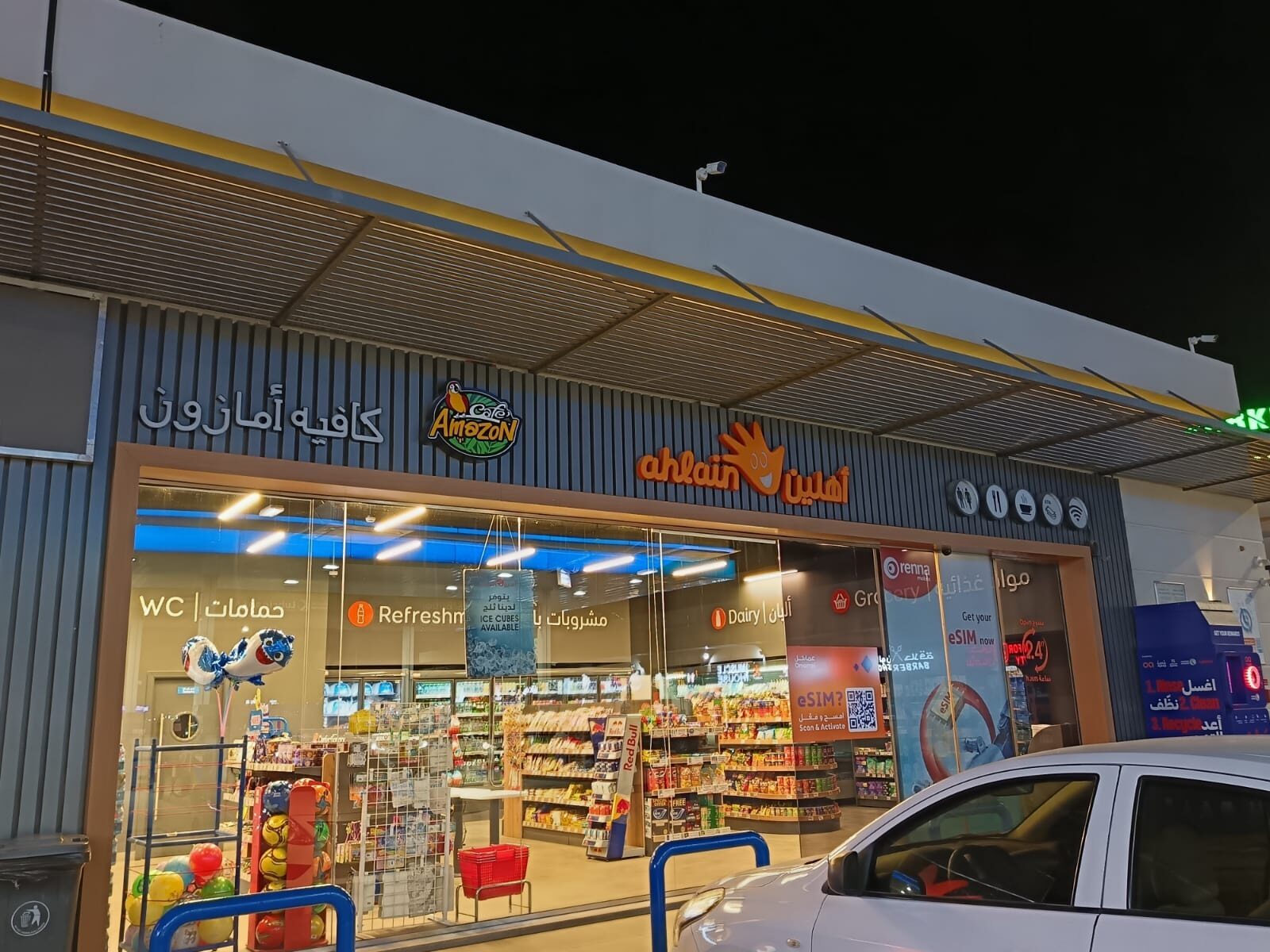 Illuminated Café Amazon and Ahlain storefront signage across a shared shopfront