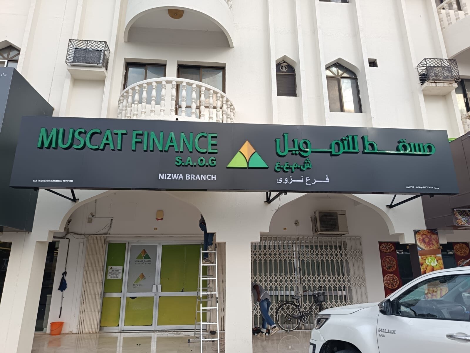 Muscat Finance branch signboard mounted on the building exterior